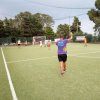 Partita di calcetto all'aperto con giocatori e arbitro.