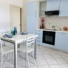 Cucina moderna con mobili azzurri e tavolo bianco apparecchiato.