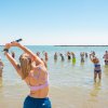 Lezione in acqua con gruppo che segue un istruttore al mare.