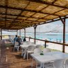 Terrazza con tavoli bianchi e vista mare.