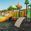 Parco giochi con scivoli arancioni e gialli.