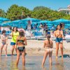Persone in spiaggia con ombrelloni blu.