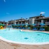 Piscina all'aperto con lettini e ombrelloni.