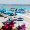 Spiaggia con ombrelloni blu e lettini.