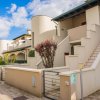 Complesso residenziale moderno con scale e giardino.