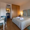 Camera da letto luminosa con letto matrimoniale, scrivania e bagno annesso.