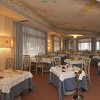Ristorante elegante con tavoli apparecchiati e decorazioni floreali sul soffitto.