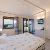 Camera con letto matrimoniale, vista mare, TV e accesso balcone.