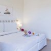 Camera d'albergo con letto matrimoniale, quadro di barche a vela e colazione su vassoio.