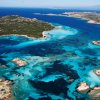 Vista aerea di un'area costiera con acque turchesi e isole rocciose verdi.