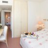 Camera d'albergo luminosa con letto matrimoniale e scrivania.