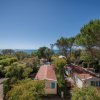 Case mobili tra alberi, vista mare in lontananza.