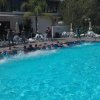 Persone in fila lungo una piscina.