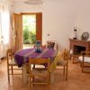 Sala da pranzo con camino, tavolo tondo e arredamento semplice.