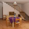 Sala con tavolo, scala e arredi essenziali.
