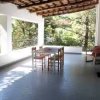 Veranda con tavolo e sedie, vista su alberi.