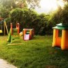 Parco giochi con altalena e scivoli colorati.