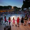 Gruppo di bambini che ballano in cerchio al tramonto.