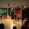 Persone assistono a un'esibizione su un palco.