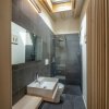Bagno moderno con finestra sul soffitto e doccia a pioggia.