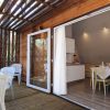 Veranda in legno con tavolo e sedie bianche.