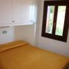 Camera da letto con copriletto arancione, finestra con vista verde.