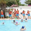 Animatori in piscina con bambini che giocano.