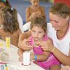 Bambina e adulta fanno lavoretti a un tavolo.