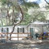 Casa mobile in un bosco con veranda e gazebo.