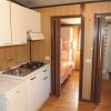 Cucina compatta con letto a castello in fondo.