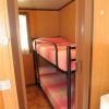 Letto a castello con coperte rosa in una stanza con pareti in legno chiaro.
