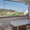 Terrazza coperta con tavolo bianco e sedie, vista collinare.