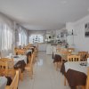 Sala da pranzo con tavoli apparecchiati.