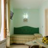 Soggiorno con divano verde e tavolo piccolo.