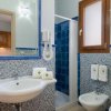 Bagno con lavabo, bidet, doccia e dettagli blu.