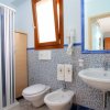 Un bagno con pareti blu, doccia, lavabo e bidet.