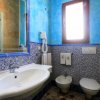 Bagno con pareti blu, lavabo, bidet e finestra.