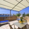 Terrazza con pergolato, sedie e sdraio blu.