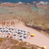 Spiaggia con ombrelloni e persone sulla sabbia.