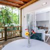 Veranda con tavolo e fiori, cucina moderna all'interno.