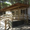 Casa mobile con veranda in legno tra gli alberi.