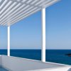 Vista mare con pergola bianca e mare blu all'orizzonte.