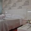 Camera con letto matrimoniale, parete decorata da parole e fiori su un tavolo.
