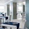 Ristorante elegante con tavoli bianchi, sedie grigie e tovagliette blu.