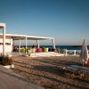 Terrazza sulla spiaggia con sedie colorate, sedie a sdraio e vista mare.