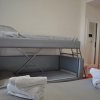 Stanza d'albergo con letto a castello argentato e asciugamani arrotolati.