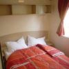 Camera da letto con letto matrimoniale e copriletto rosso.