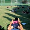 Persone stese su un prato che fanno stretching.