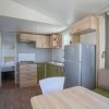 Cucina moderna con tavolo, sedie e frigorifero.