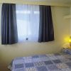 Camera da letto con letto matrimoniale, coperte a quadri e tende scure.